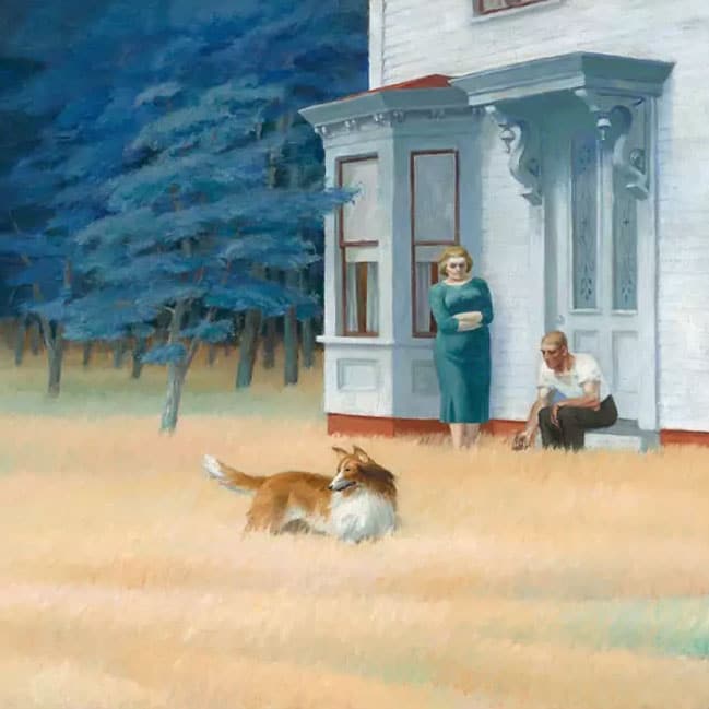 Man and woman near white house porch with fluffy dog in tall grass and blue trees background
